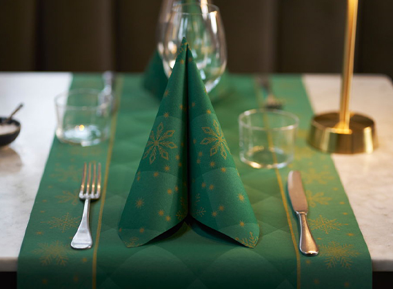 Green festive place setting with folded napkin and table runner